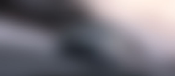 Dodge Charger SIXPACK sports car speeds on a snowy road with barren trees and a cloudy sky in the background, creating a dynamic and intense scene.