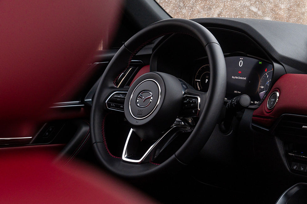 Close-up of Mazda CX-70 PHEV interior with a black steering wheel showing its logo, red accents, and a dashboard displaying "Key Not Detected."
