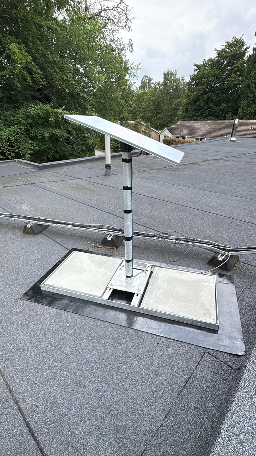 Eye-level view of a technician installing a Starlink satellite dish on a rooftop