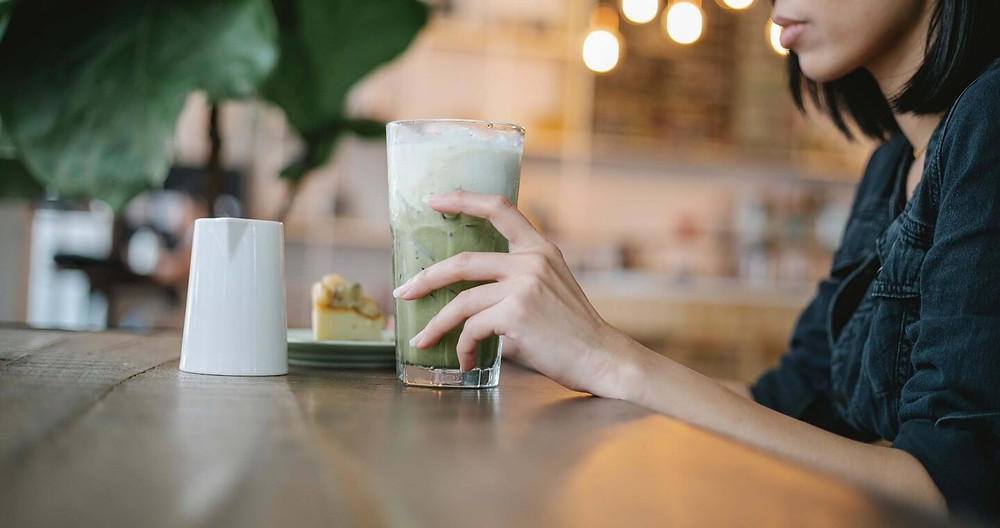 cô gái thưởng thức matcha latte tại quán cafe