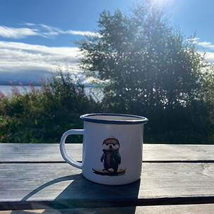 Kaffeebecher auf Holztisch vor sonnigem Himmel