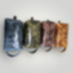 Several leather shaving bags in a row in different colours.