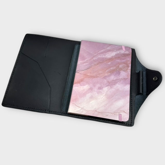 Thumbnail: The inside of a black leather book cover with a snap enclosure.