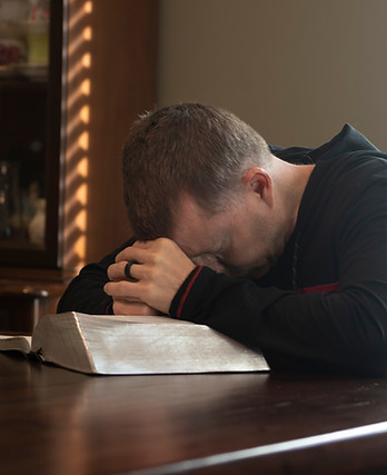 Man praying over the bible