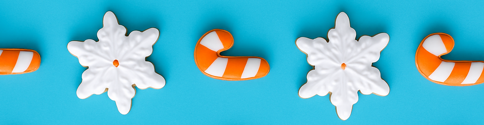 white snowflake cookies and white and orange candy cane cookies on a blue background