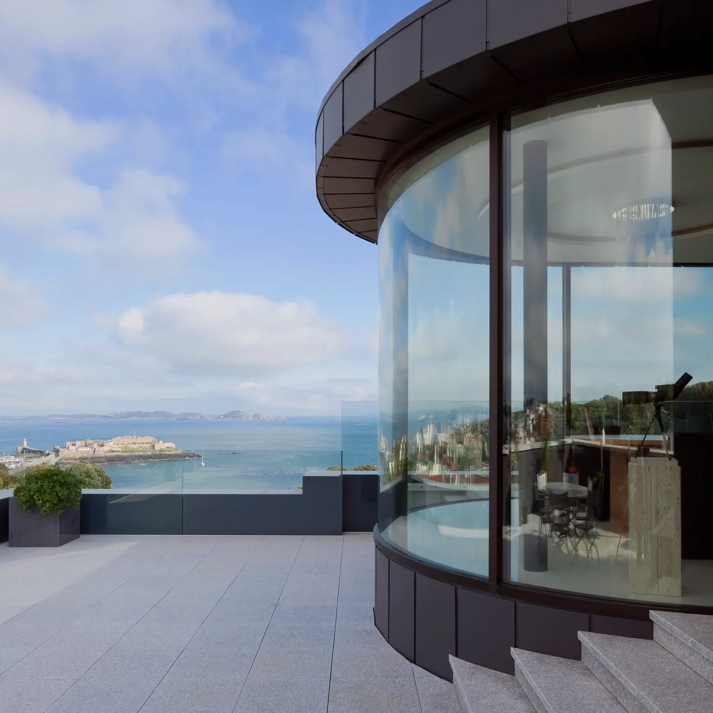 View of the terraces and balconies facing east, framed to capture sweeping sea views and Castle Cornet silhouette across the bay