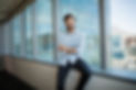 Une homme est debout au travail, il sourit avec confiance en lui.