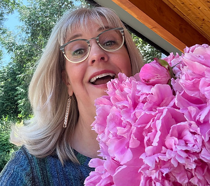 Laura with a full bouquet of freshly picked pink peonies