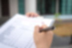 Foreman's hand is using a pen checking on building inspection report form to QC building q