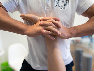 Physiotherapeut wendet Krankengymnastik bei Patient an