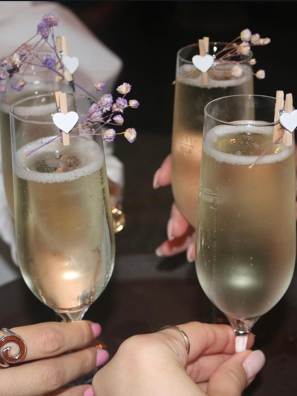 4 champagne glasses with baby breath decoration clipped to the side of each glass