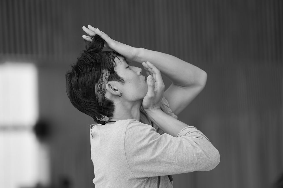 A man in profile places one hand on his jaw and the other on his forehead.