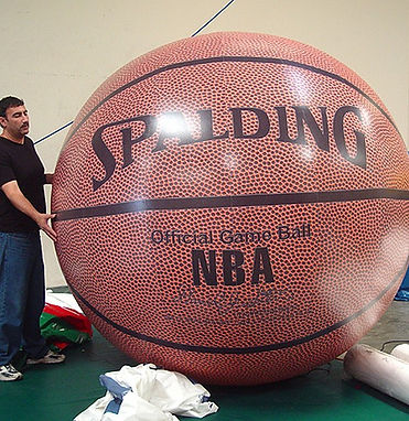 Spalding brand inflatable basketball taller than an adult standing next to it