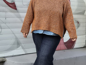 Frau in orange-braun meliertem Oversizes Pullover mit langem Arm