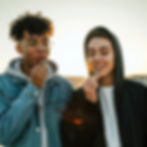 A young couple enjoying Incredibles Gummies outdoors at sunset, capturing a moment of shared joy and relaxation.