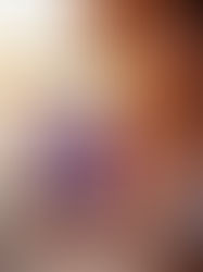 A woman at sunset on a boat holds a Coast Recovery gummy and the boysenberry-colored bag, glowing in warm golden light.