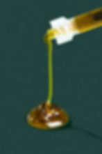 Close-up of RSO (Rick Simpson Oil) dripping from a syringe, highlighting its thick, rich texture and purity for cannabis branding and product appeal.