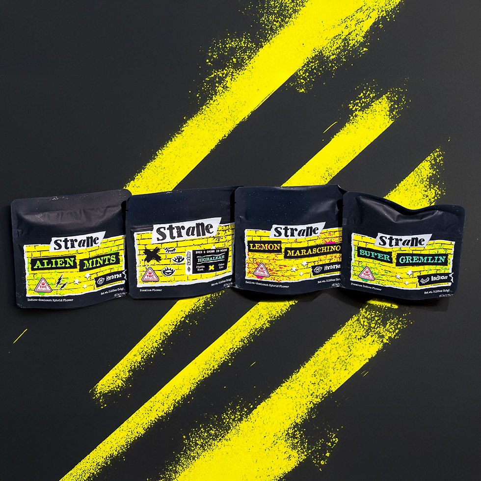 Four Strane flower bags — Alien Mints, Gator Breath, Lemon Maraschino, and Super Gremlin — arranged on a dark surface with yellow paint streaks behind them.