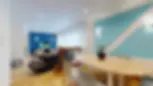 Espace ouvert lumineux avec salle à manger bois clair et salon cosy aux murs bleu profond. Colocation Confluences à Gaillard.