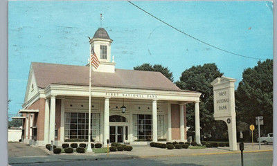 Vintage view of First National Bank of McConnelsville at 86 North Kennebec Avenue in McConnelsville, Ohio, with its columned entrance, cupola and American flag.