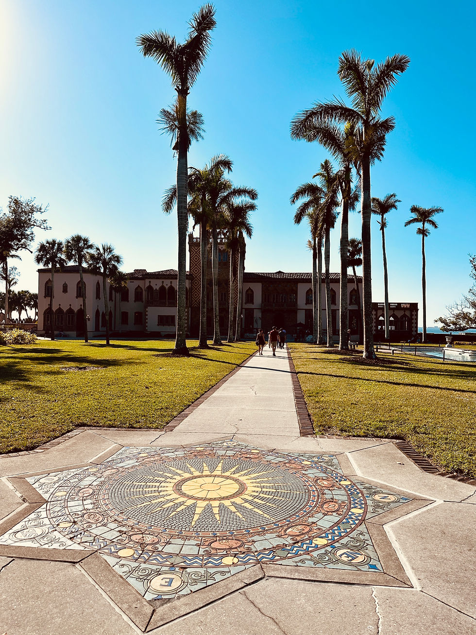 Palm tree-lined walkway to a 1920s bayfront mansion.