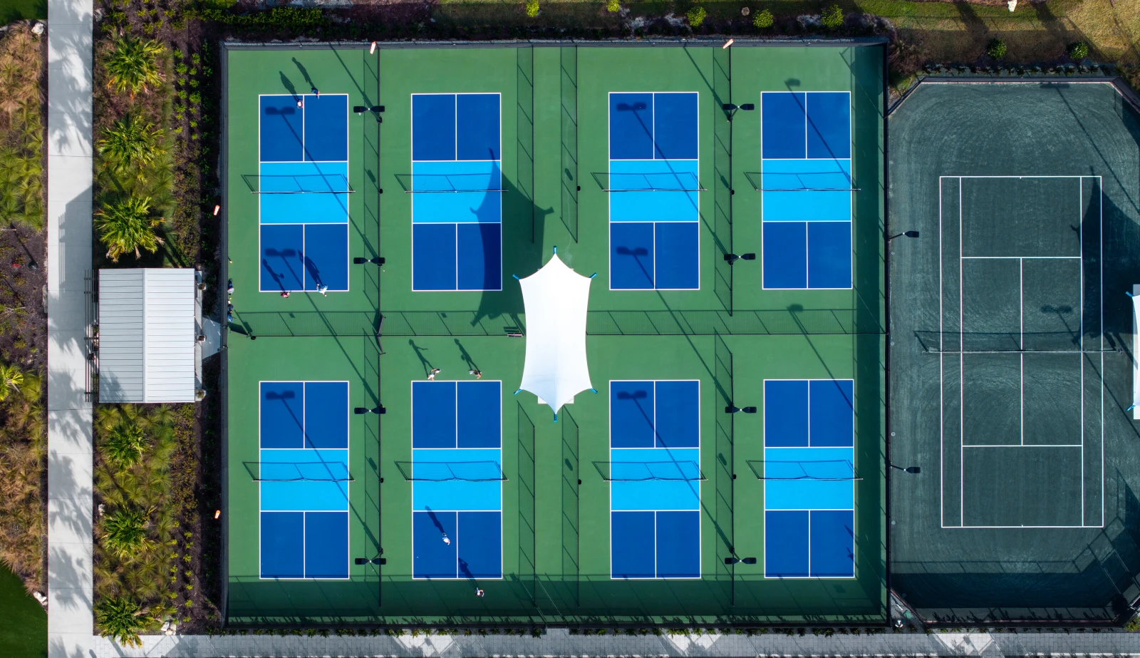 Aerial view of multiple blue and green pickelball courts.