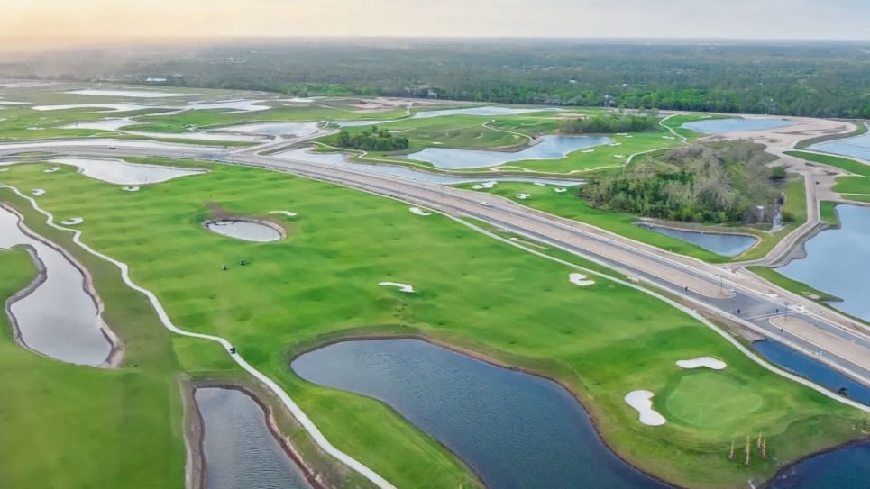 Aerial view of golf fairways and ponds.