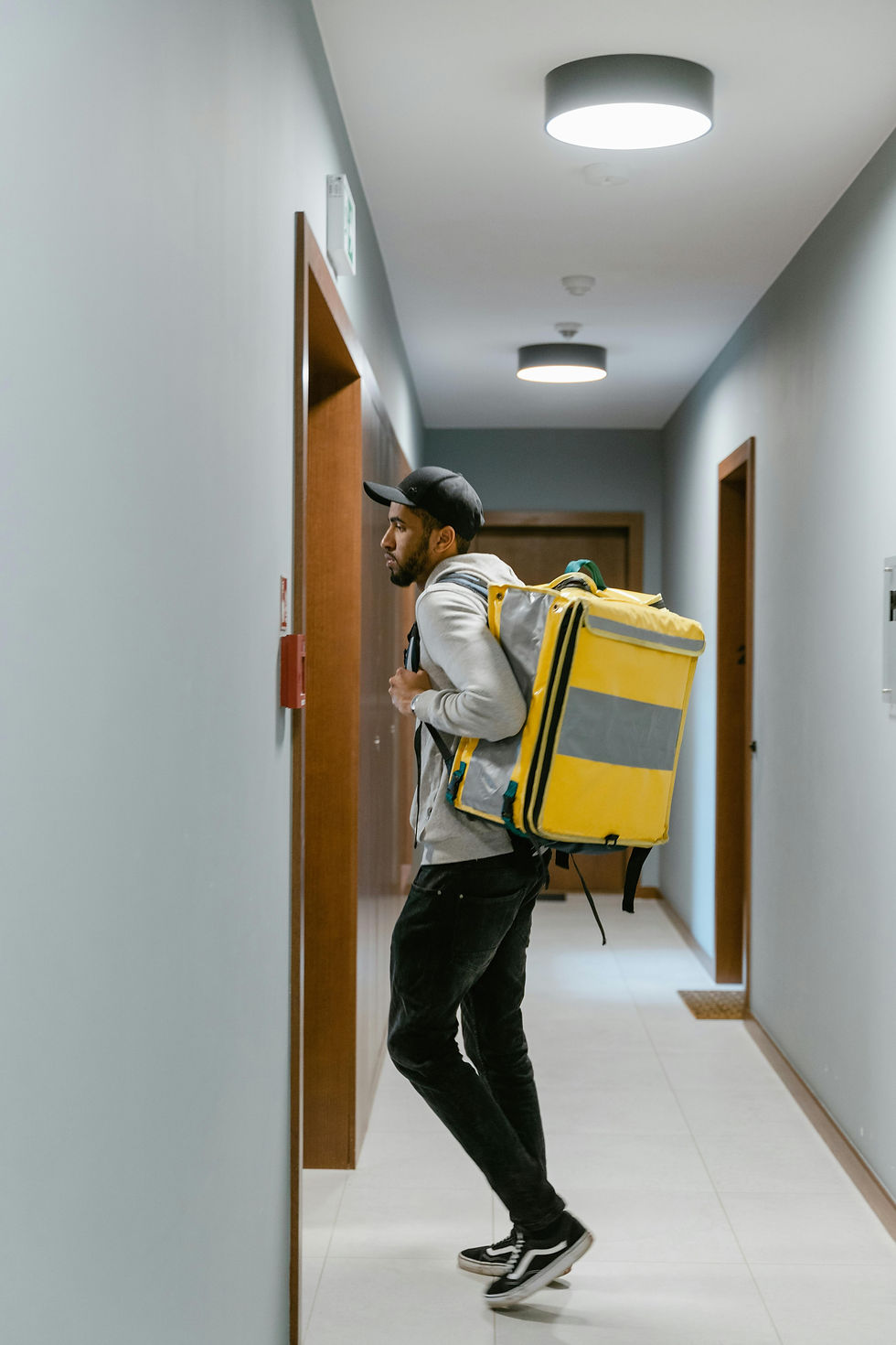Delivery person with thermal backpack at doorway