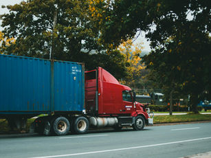 Fleet of cargo trucks transporting goods on a highway under clear skies