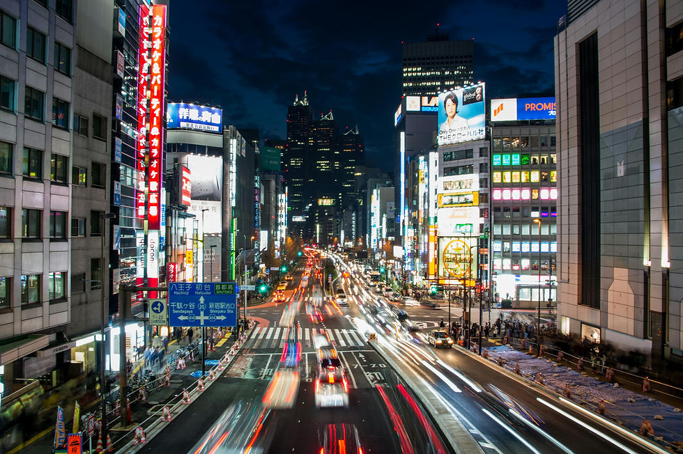 Vibrant Tokyo street at night, illuminated buildings, traffic streaks