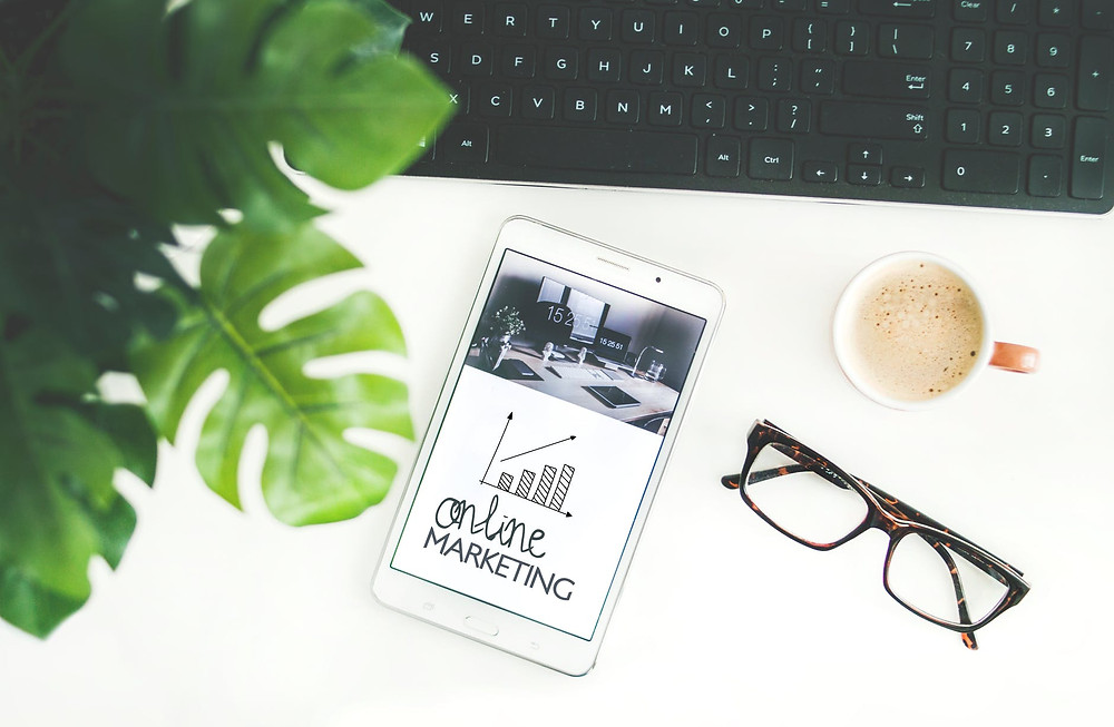 telefono con scritta online marketing poggiato sopra una scrivania