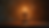 Close-up view of a candle burning in front of a cross, symbolizing faith and sacrifice