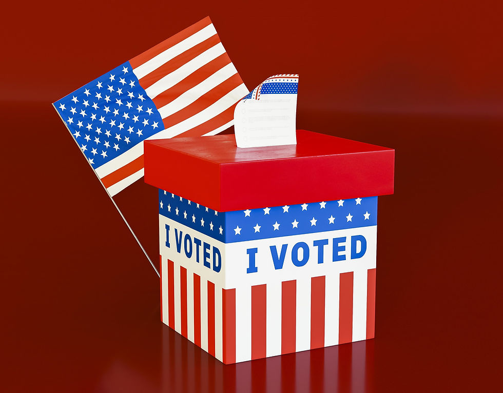 Voting box with "I Voted" text, decorated in red, white, and blue stars and stripes. An American flag in the background on a red surface.