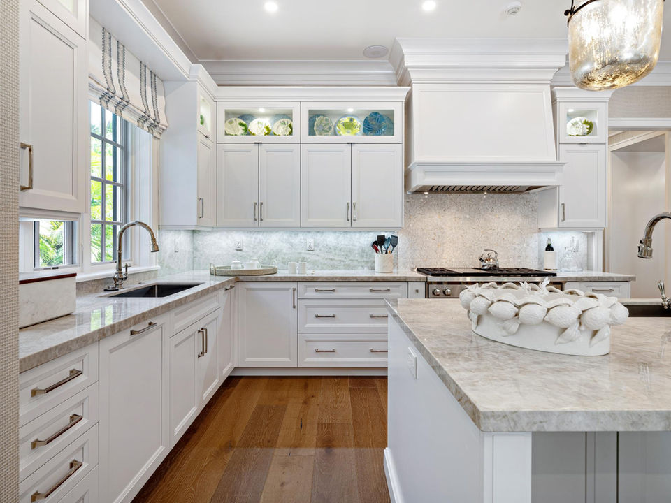 Traditional white kitchen with marble island and wood flooring