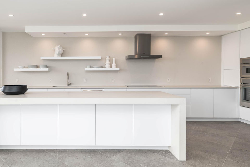 Modern white kitchen with minimalist design and floating shelves