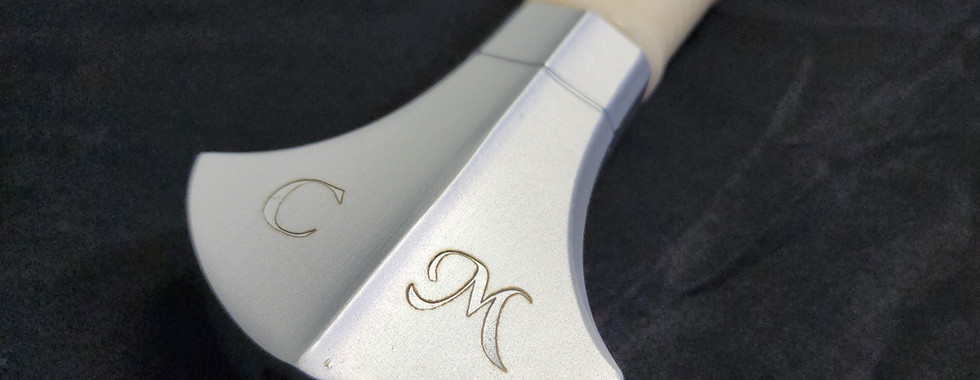 A laser engraved sword handle with initials engraved on it