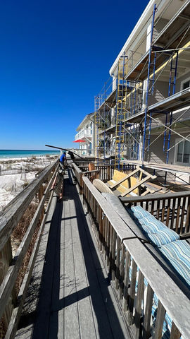 Wooden boardwalk leads to a beach with a building under construction