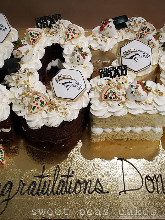 2020 number shaped graduation cake topped with cookies and chocolate covered strawberries for high school grad party