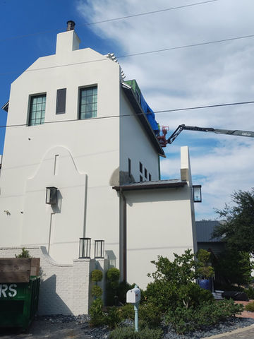 White building with a crane and visible text on a bright sunny day
