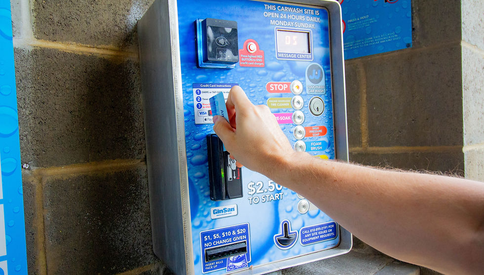 Hand inserting card into JJ Auto Wash payment machine