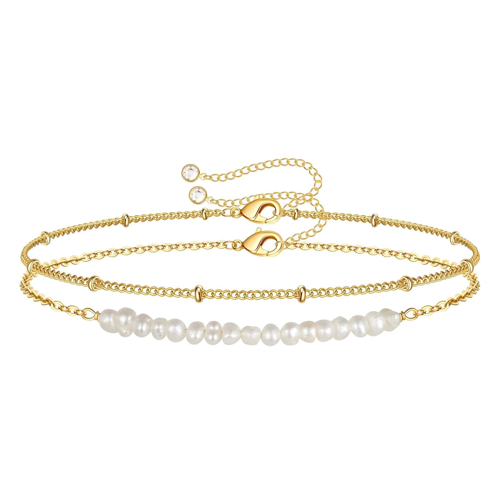 Two golden anklets with delicate chain and pearl details, accessories.