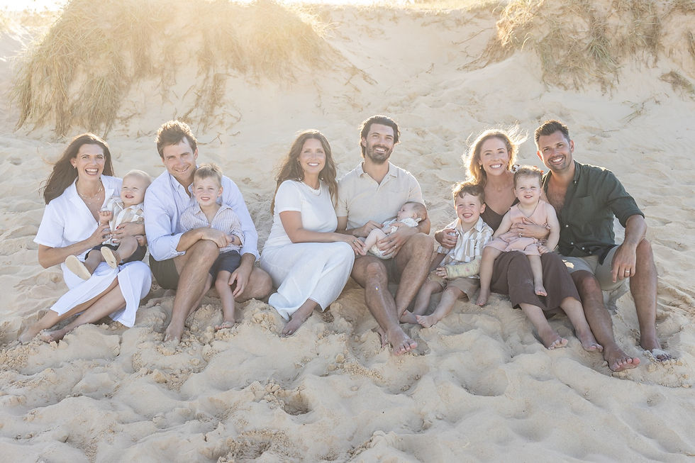 Marcus Beach family photography featuring a large extended family with well-coordinated outfits during a backlit sunset.