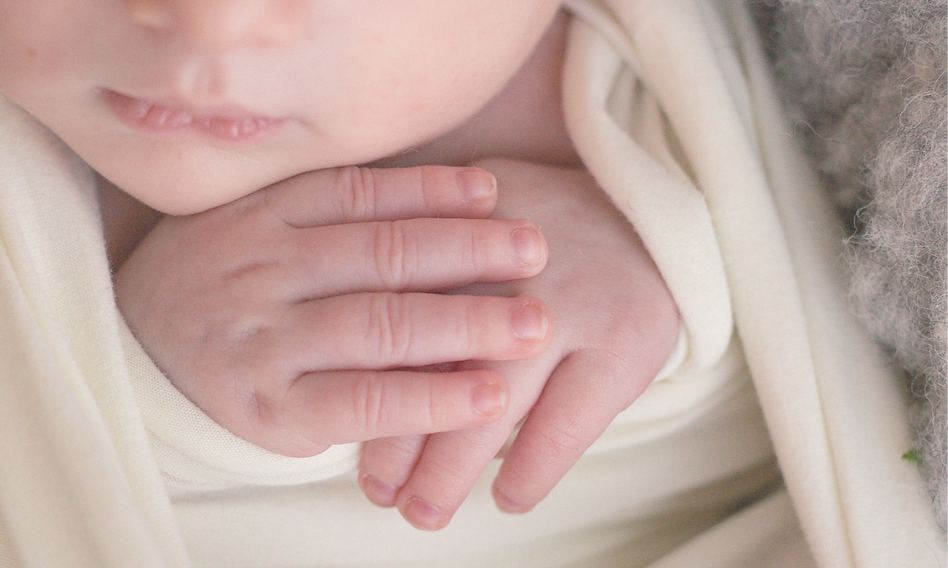 Close-up macro photograph of a newborn baby's tiny hands during a Noosa lifestyle photography session.