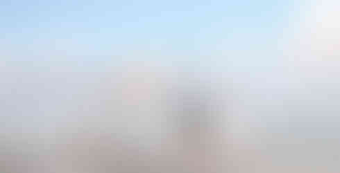 A family holding hands walking along the beach at Noosa