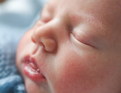 Close-up photograph of a newborn baby's face sleeping peacefully during a Noosa lifestyle portrait session.