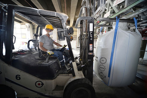 Forklift moving a large bag of concrete
