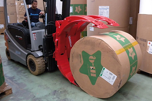 Forklift with specialized roll handling clamp moving roll of paper
