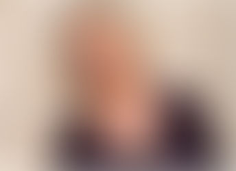 Photo of author Danna Smith leaning against a white brick wall.