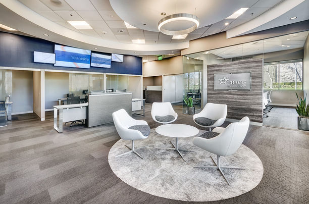Stylish financial services office lobby featuring curved white chairs, round tables, glass walls, reception desk, and modern lighting