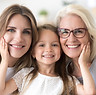 Portrait of three generations of women look at camera posing for family picture, cute litt